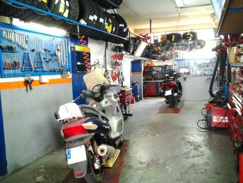 Interior del taller de Dual Motos con motos en reparación y herramienta